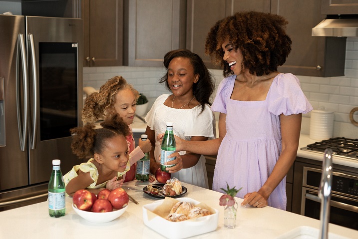 black mom cooking with daughter in kitchen